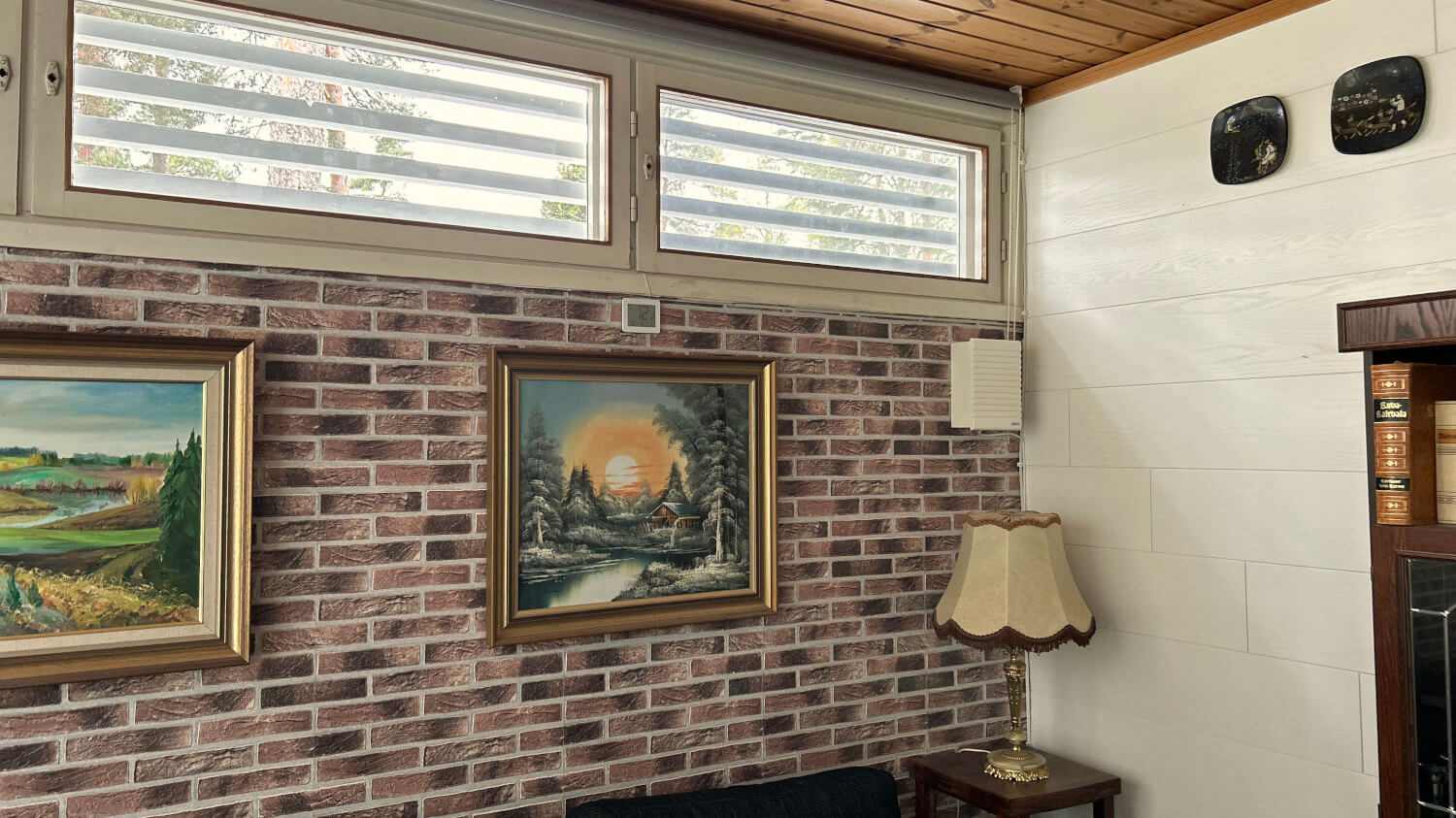 Room interior with Mobair K fresh air valve mounted on the wall, framed pictures, and a lamp.