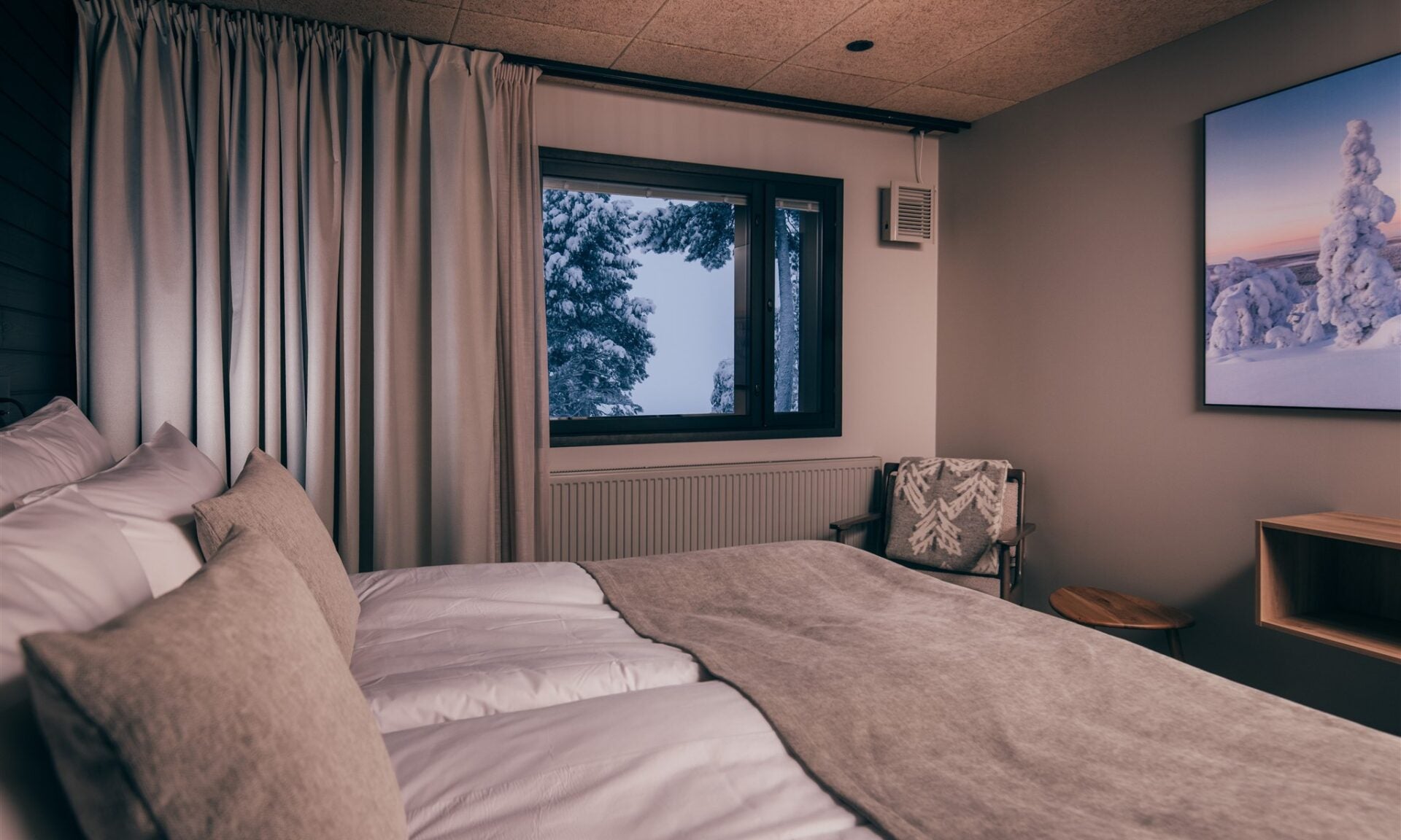 Mobair valve on bedroom wall, window with trees, and armchair with blanket